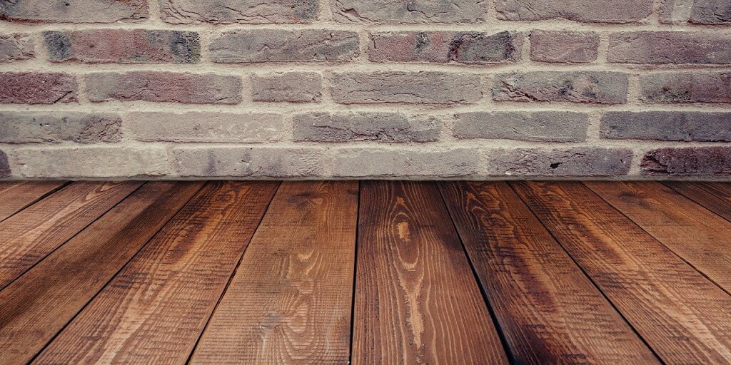 Neutral interior background with brick wall and wooden floor