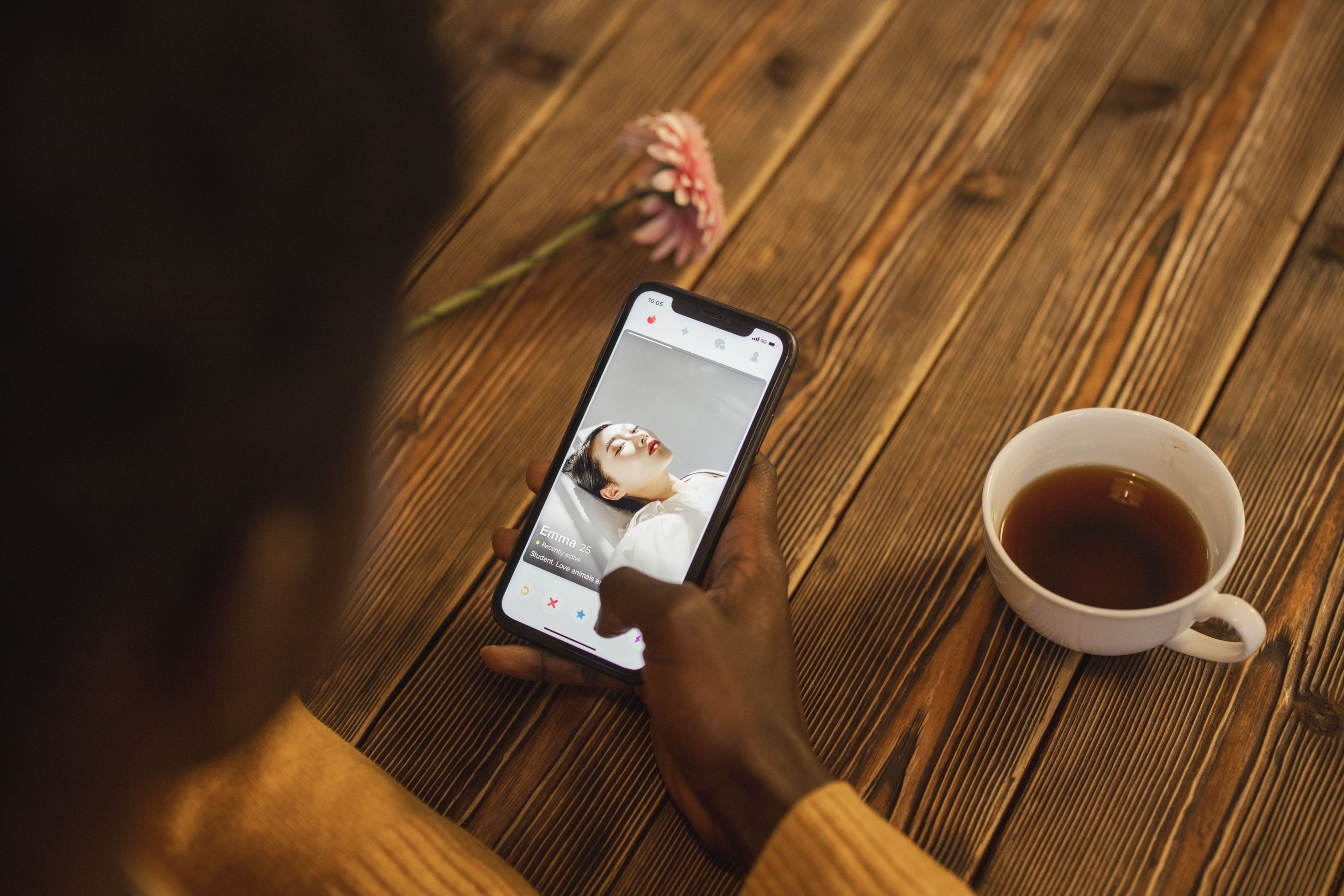 Person browsing a dating app on a smartphone at home