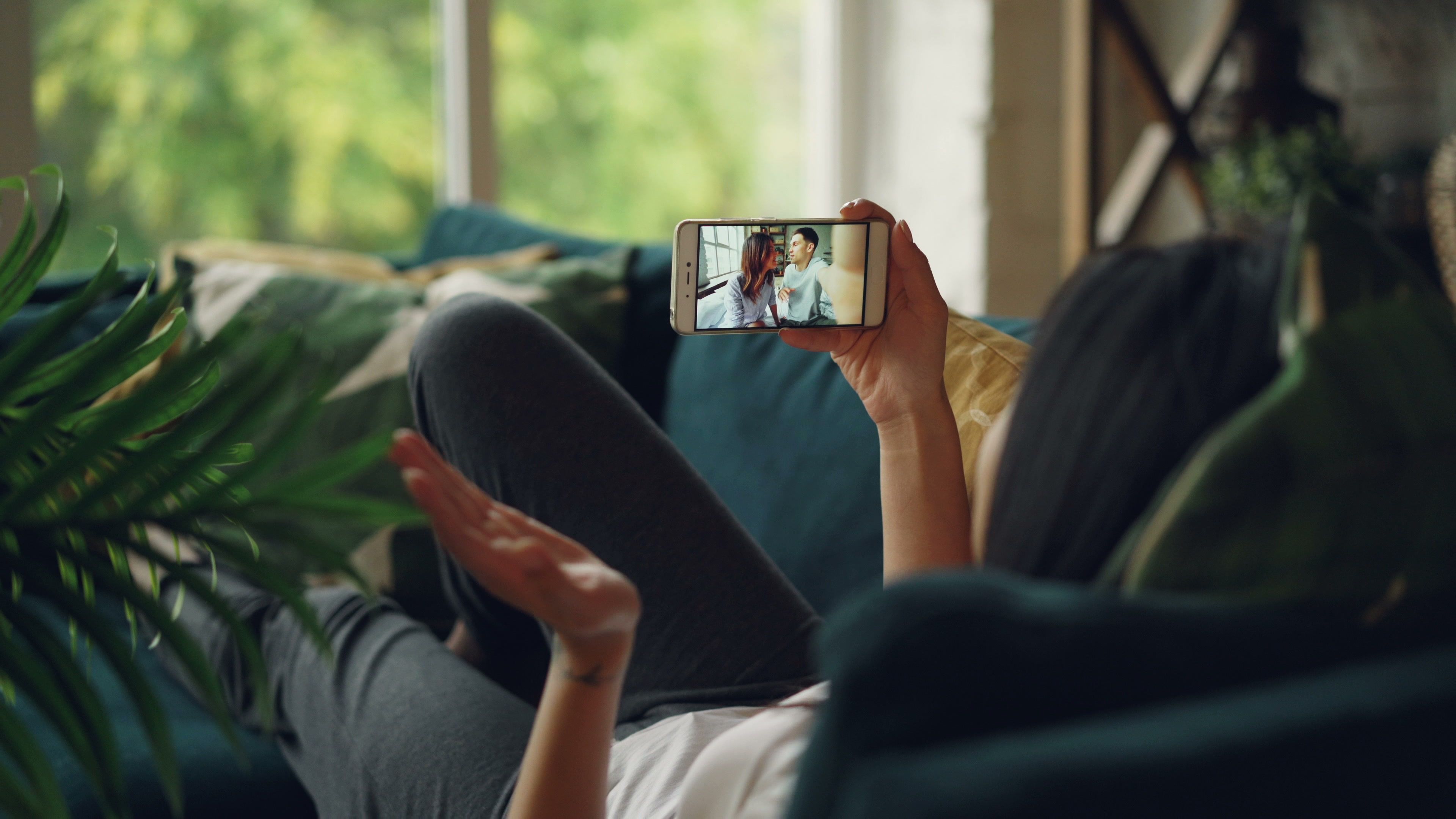 Woman relaxing at home while talking with someone on a video call